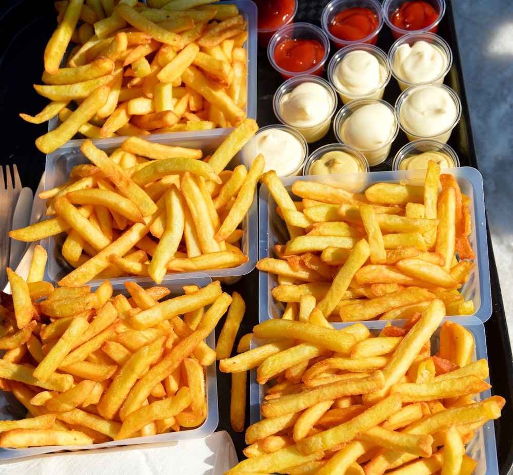 a tray of french fries with dips and condiments