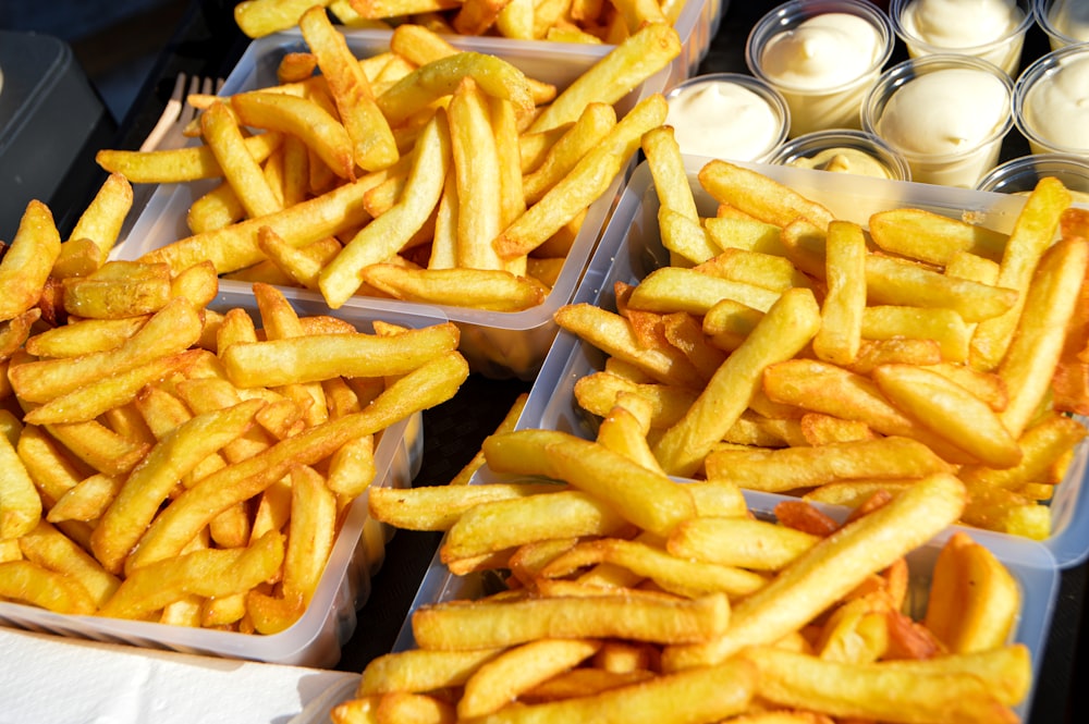 several trays of french fries sitting on a table