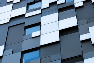 An elegant commercial building facade featuring geometric patterns and subtle grayscale tones.