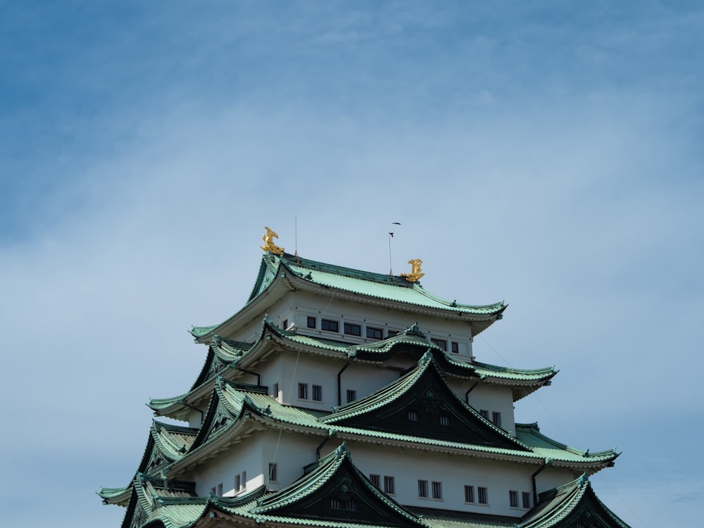 a tall white building with a green roof