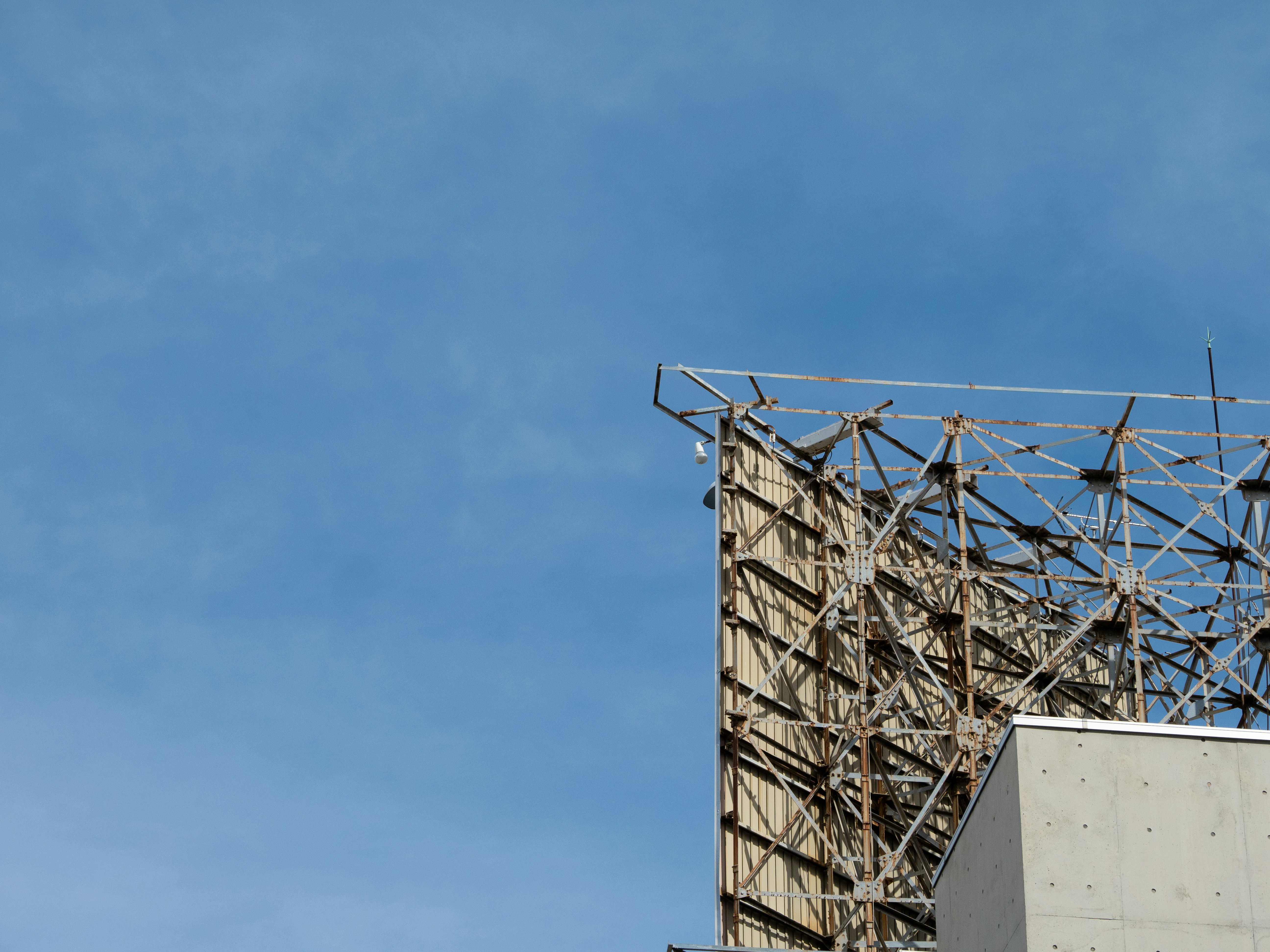 Tall unipole advertising structure at highway intersection, clear sky, large format billboard