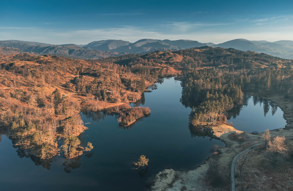 an aerial view of a lake surrounded by mountains