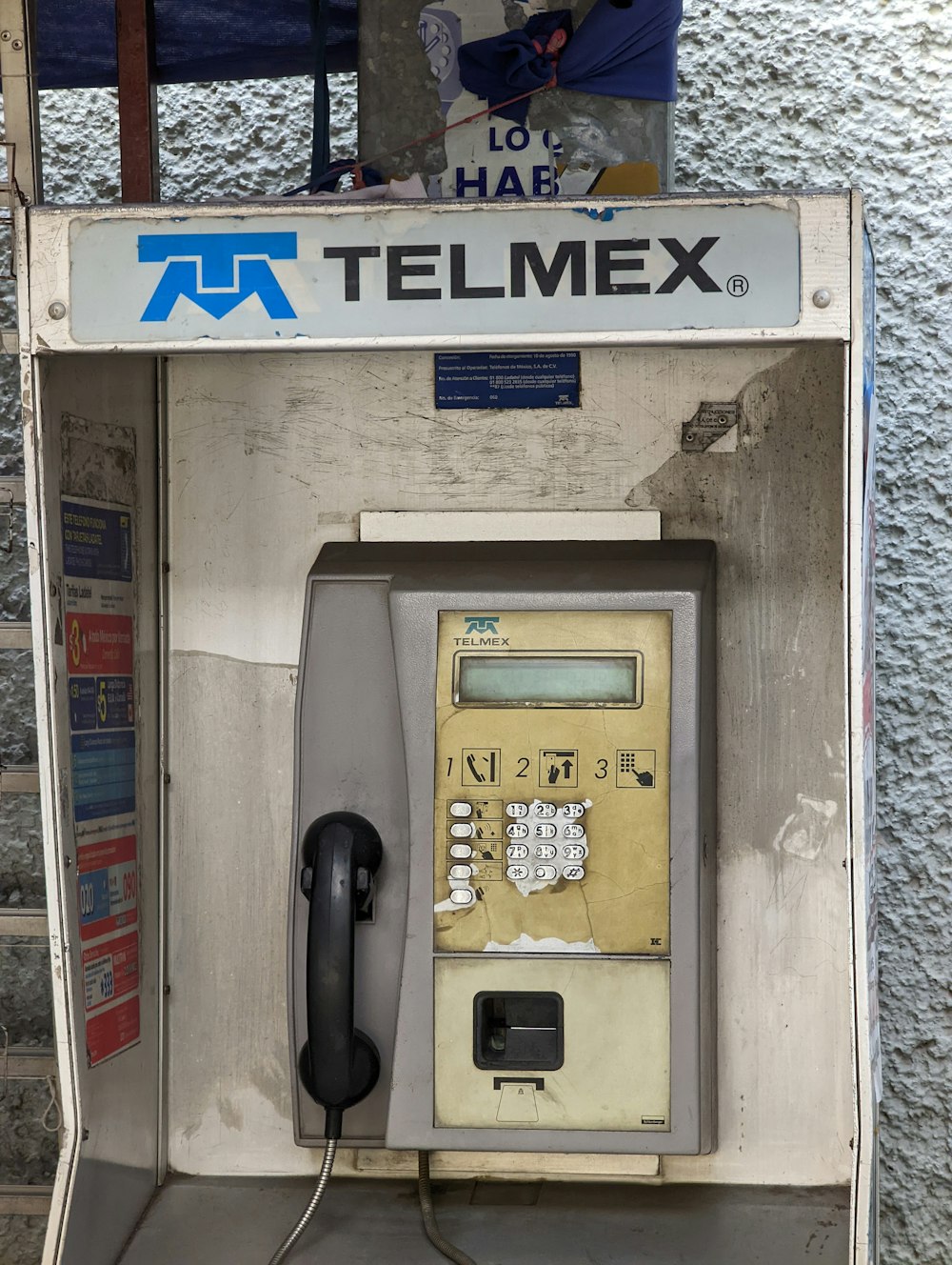 an old fashioned payphone with a phone on top of it
