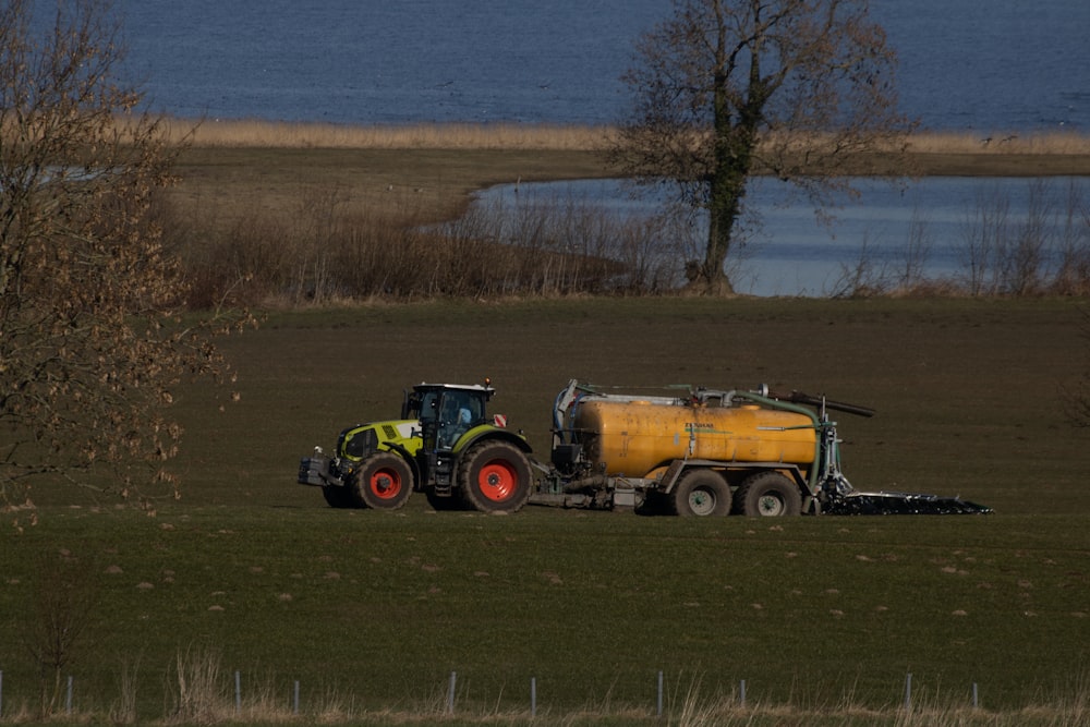 a tractor pulling a yellow trailer behind it