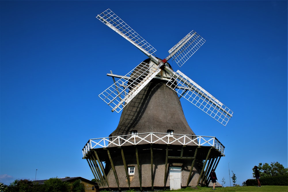 Un gran molino de viento sentado en la cima de un exuberante campo verde