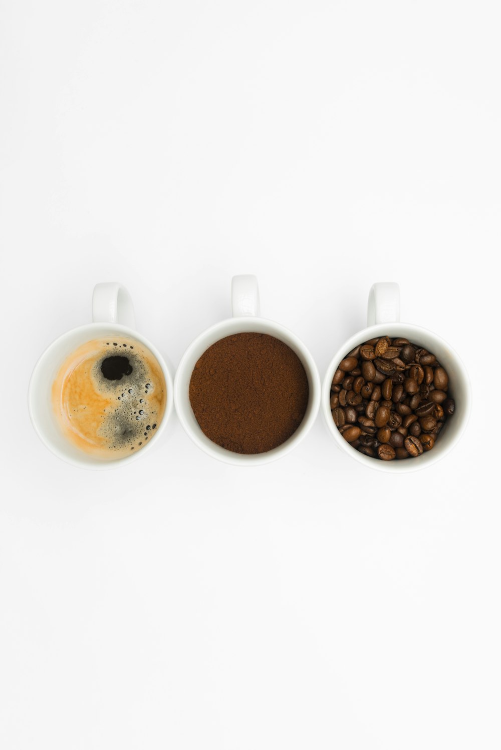 three coffee mugs filled with different types of coffee