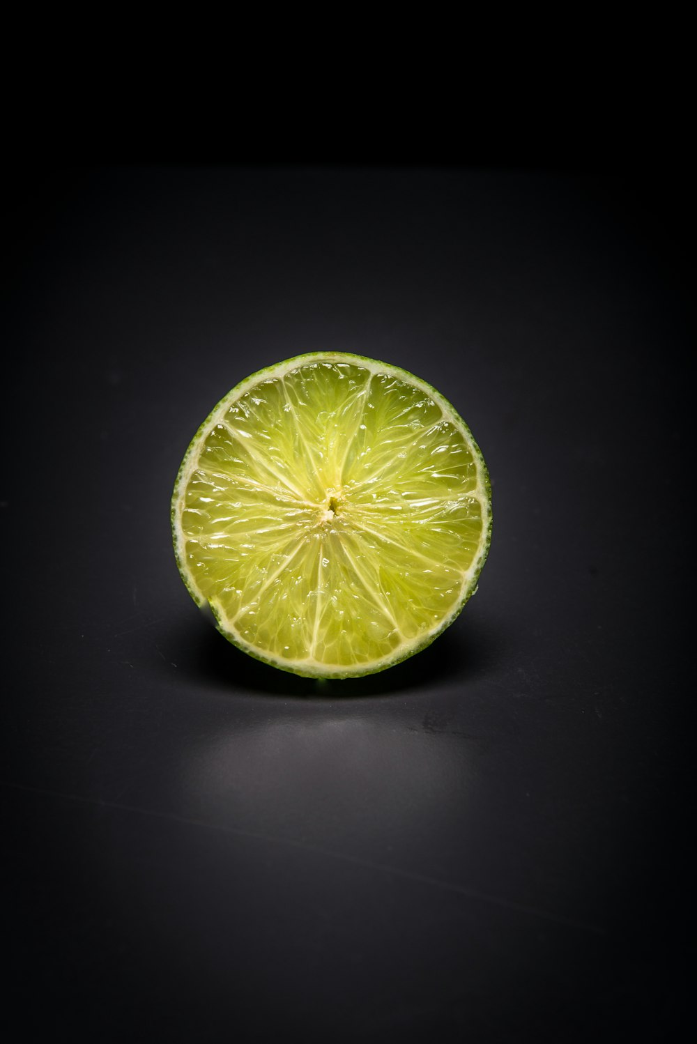 a lime cut in half on a black surface