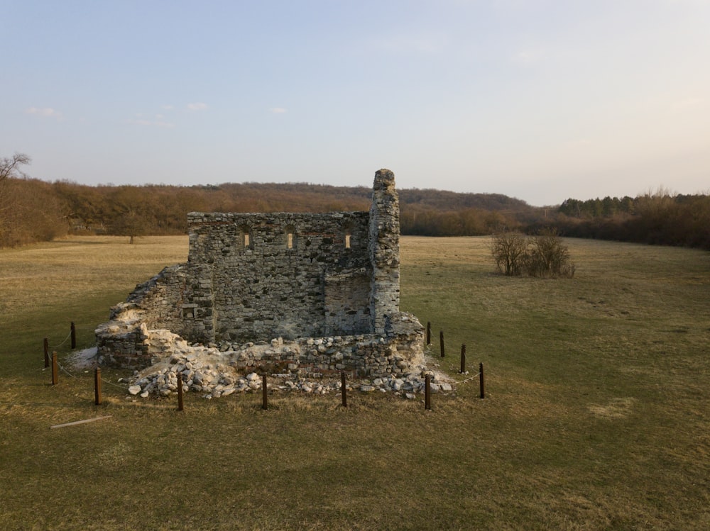 an old stone building sitting in a field