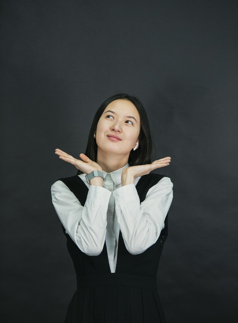 a woman in a black and white dress making a hand gesture