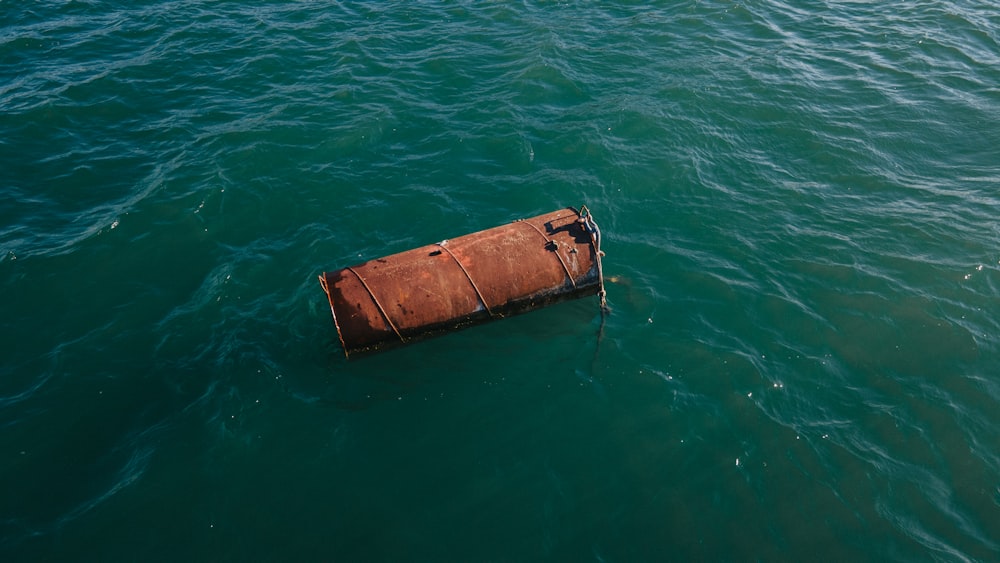 a rusty buoy floating in the middle of a body of water