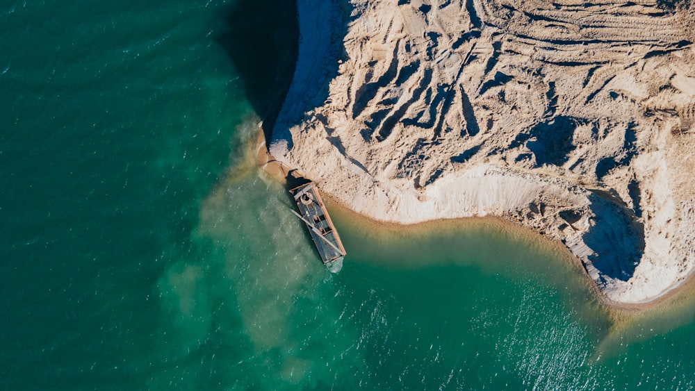 an aerial view of a boat in a body of water