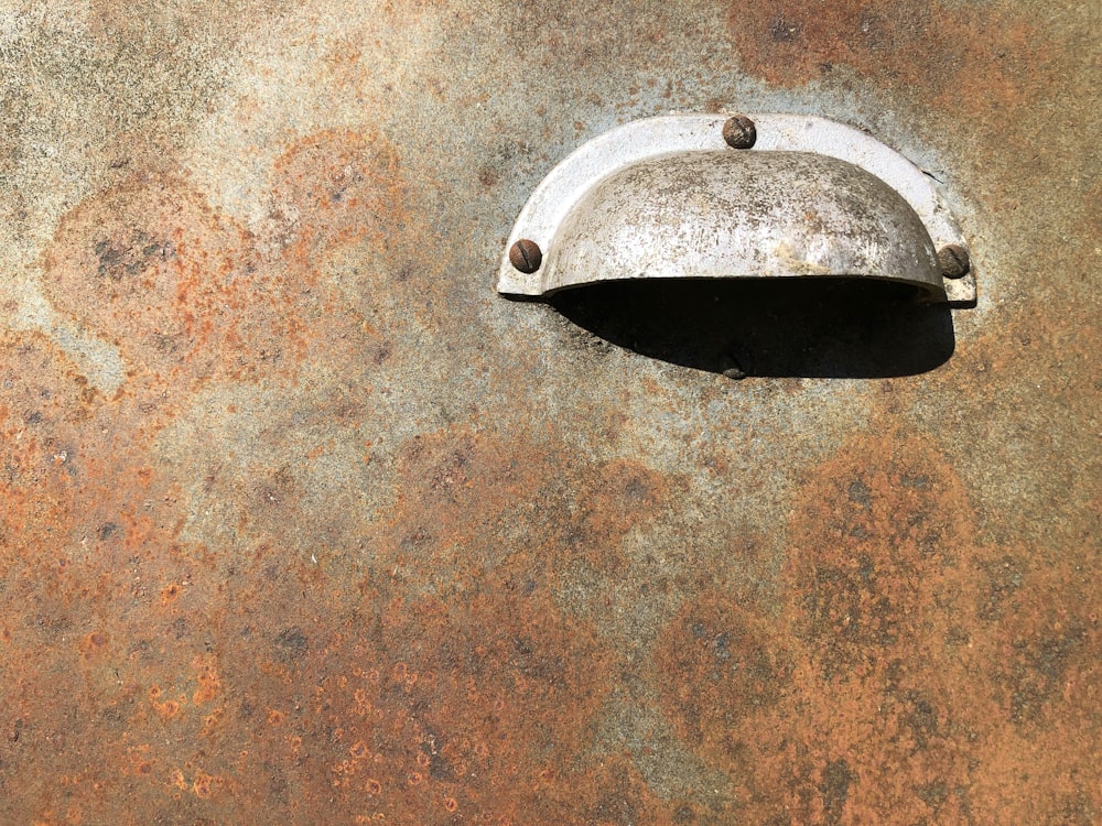 a rusted surface with a metal object on it