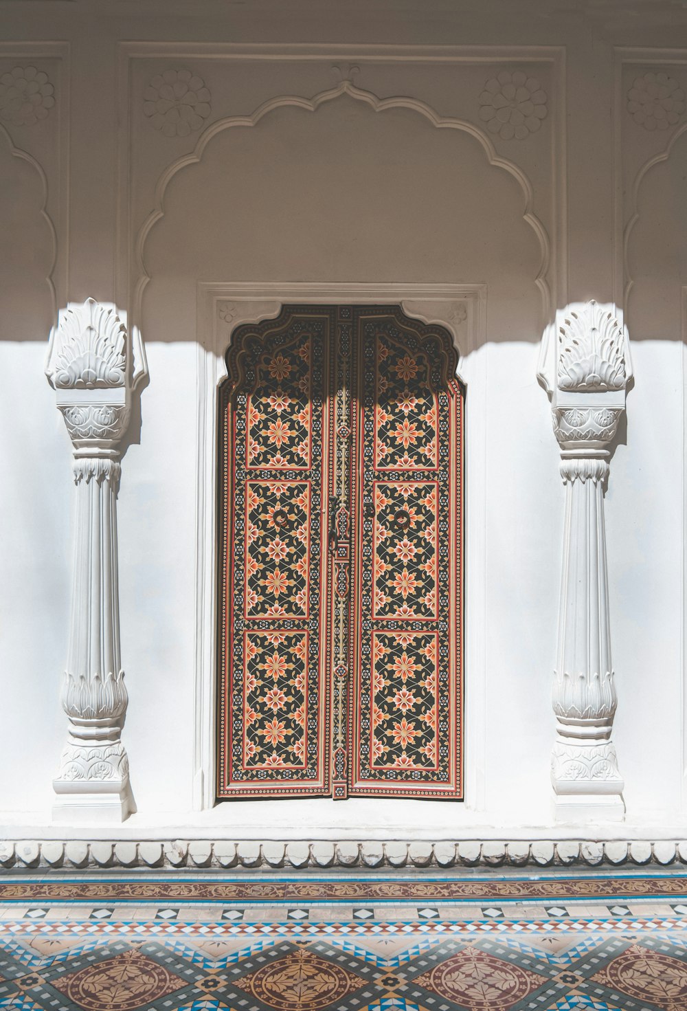 a doorway with a decorative door and pillars