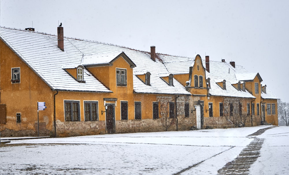 a row of yellow houses covered in snow