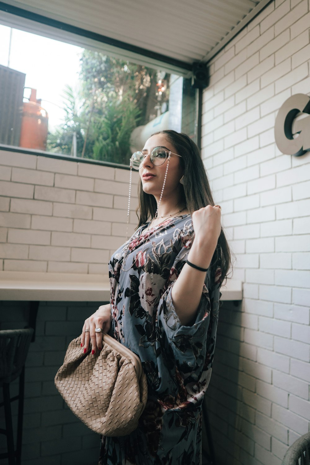 a woman standing in front of a white brick wall