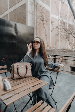 a woman sitting at a table talking on a cell phone