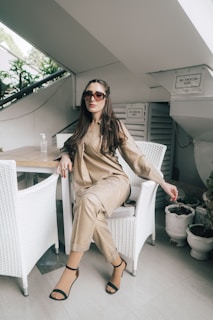 a woman sitting on a chair wearing sunglasses