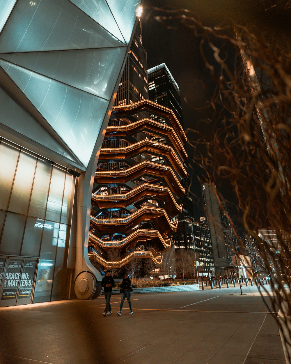 a couple of people standing in front of a tall building