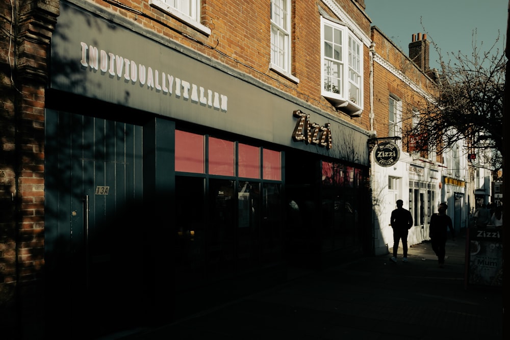 a man walking down a street next to a tall brick building