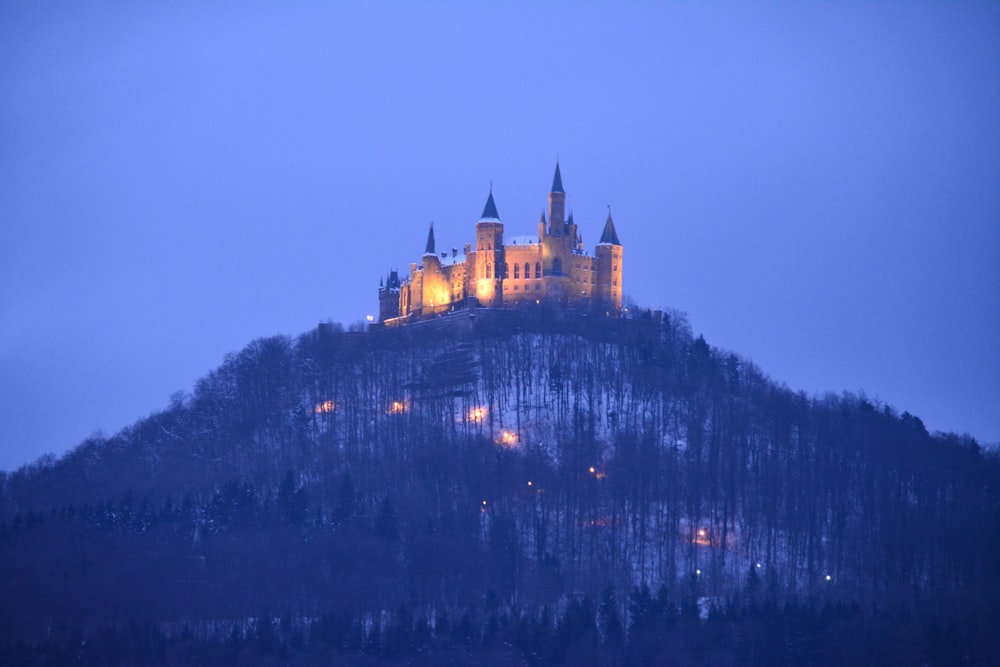 a castle on top of a hill lit up at night