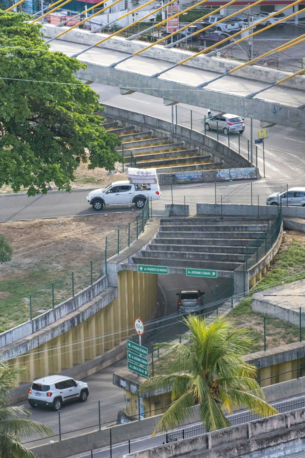 a car driving down a street next to a set of stairs