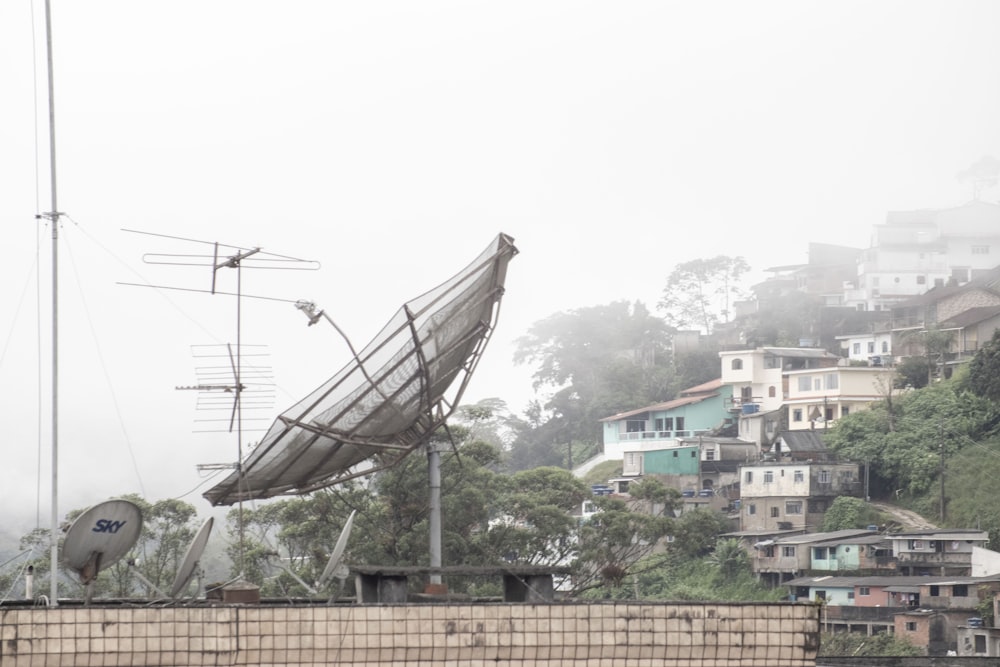 uma antena parabólica sentada no topo de um edifício