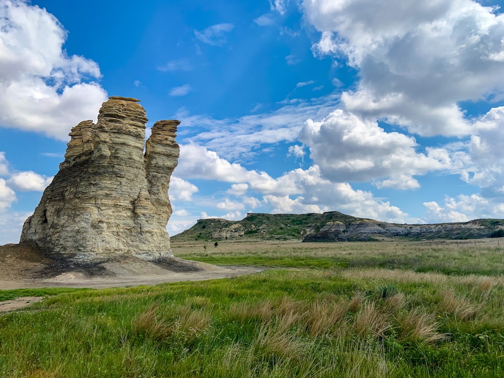 a large rock formation in the middle of a field