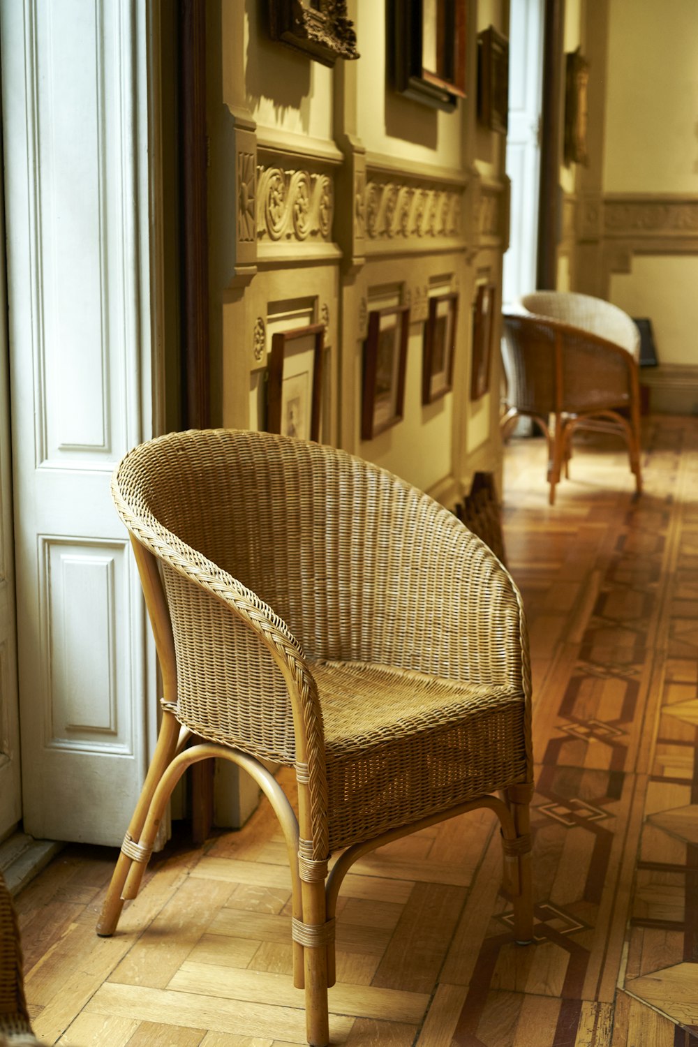 a wicker chair sitting in a room next to a doorway