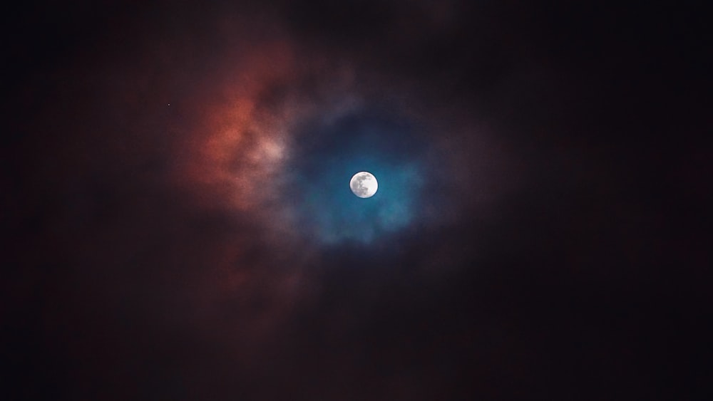 the moon is seen through the clouds in the night sky