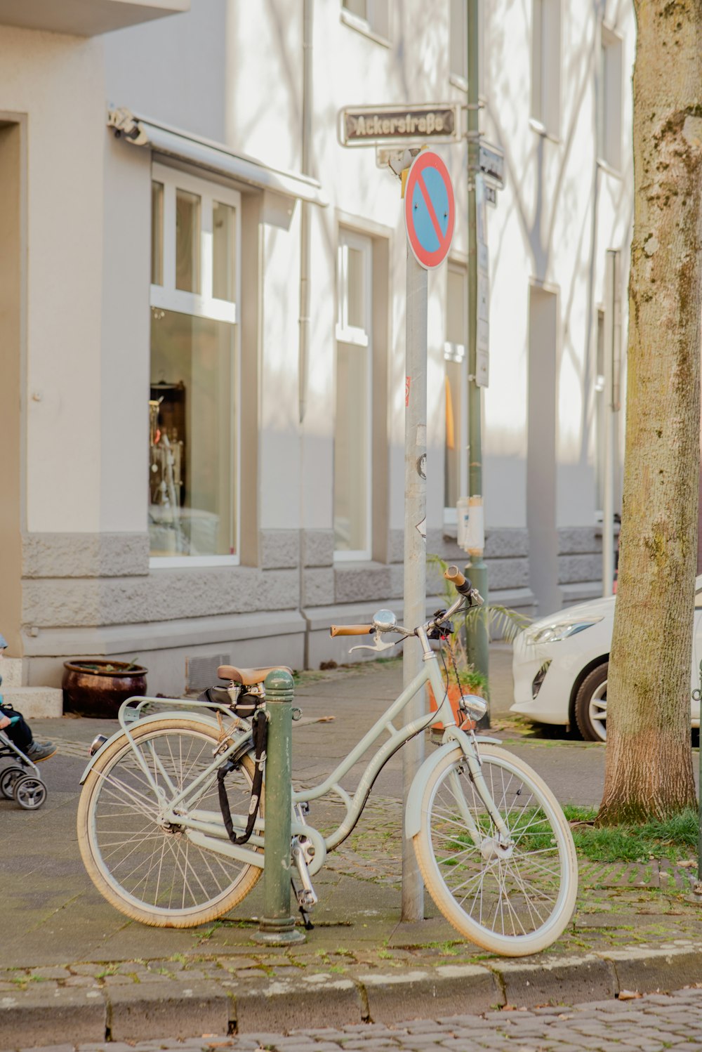 a white bicycle parked on the side of a street