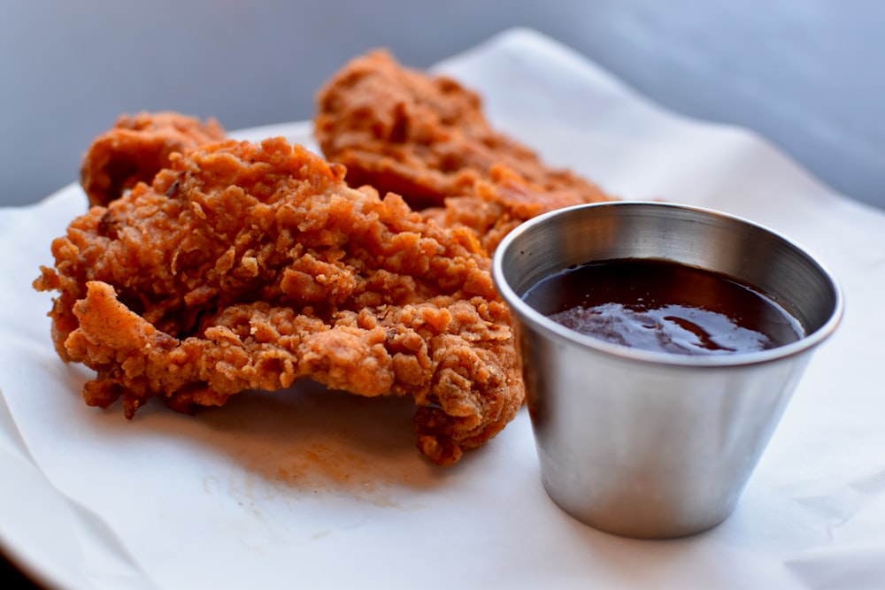 a plate of fried food next to a cup of sauce