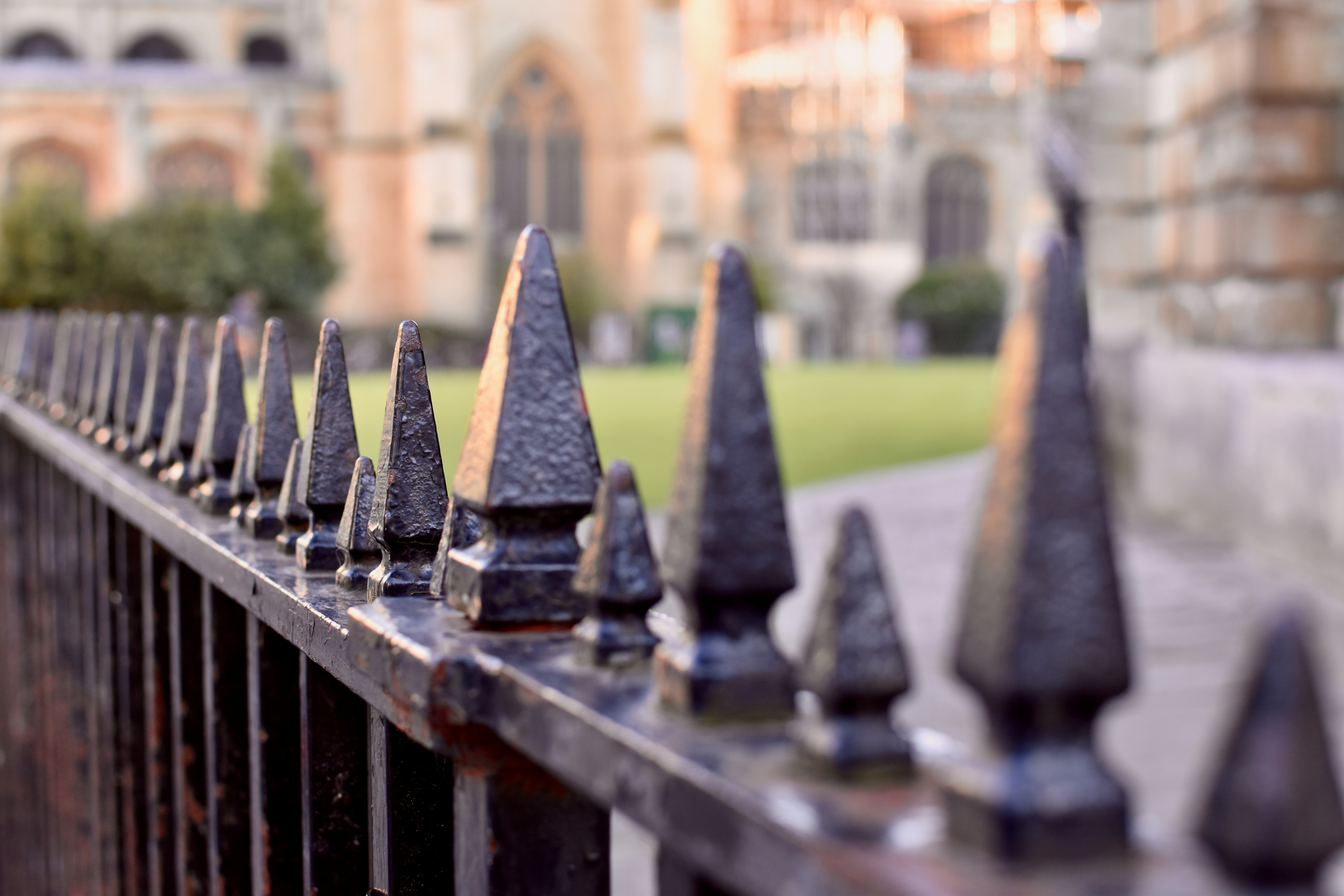 ein Metallzaun mit einem Gebäude im Hintergrund