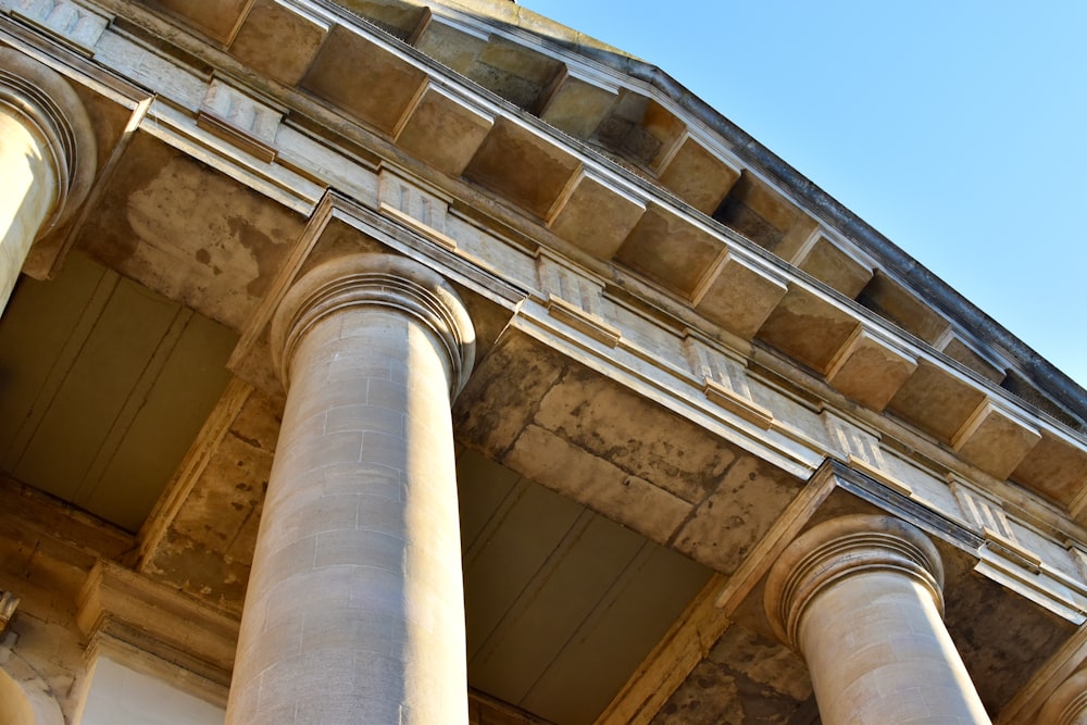 a tall building with columns and a clock on the top of it