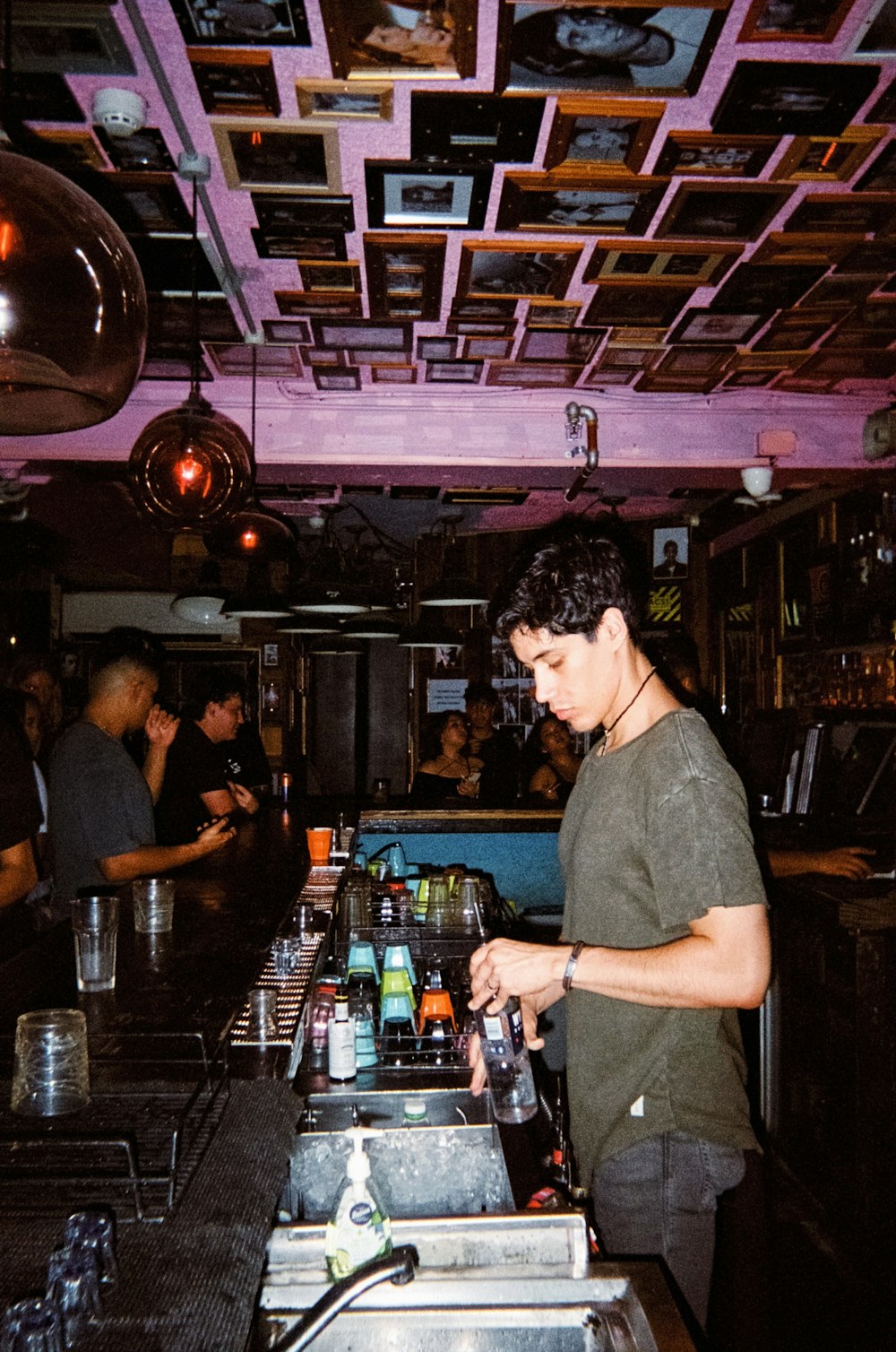 a man standing at a bar making a drink