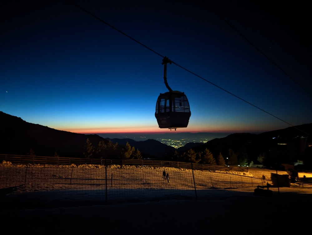 a ski lift with a view of a city at night