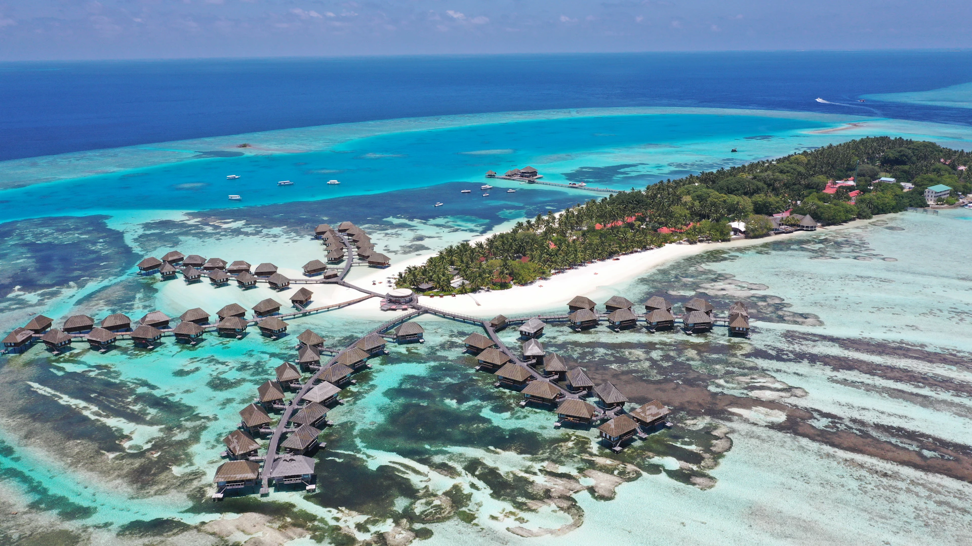 an aerial view of a resort in the middle of the ocean
