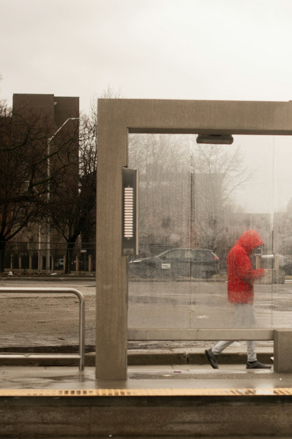 a person in a red jacket walking in the rain