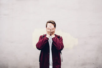 a man covering his face with his hands
