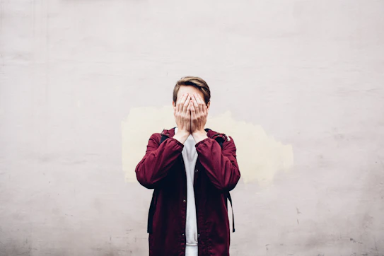 a man covering his face with his hands