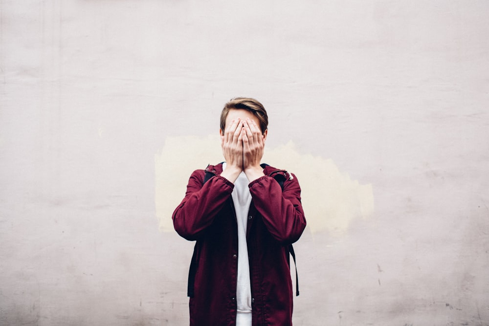 a man covering his face with his hands