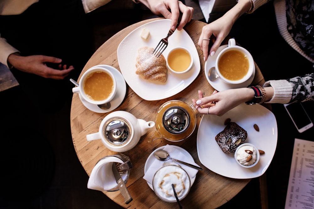 a group of people sitting at a table with plates of food