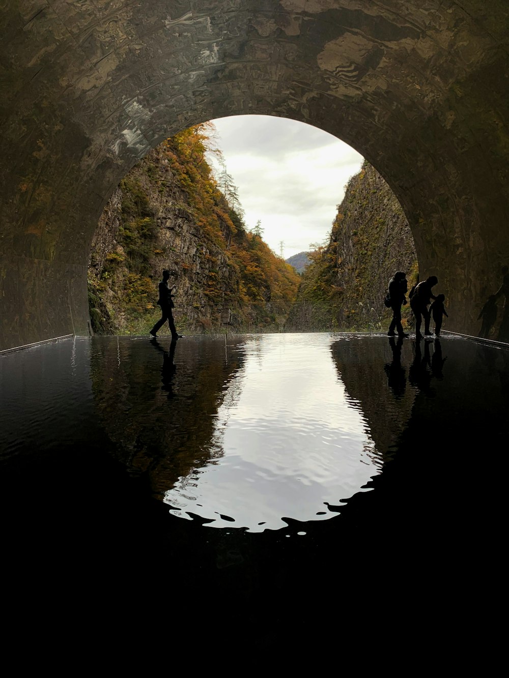 a group of people walking through a tunnel