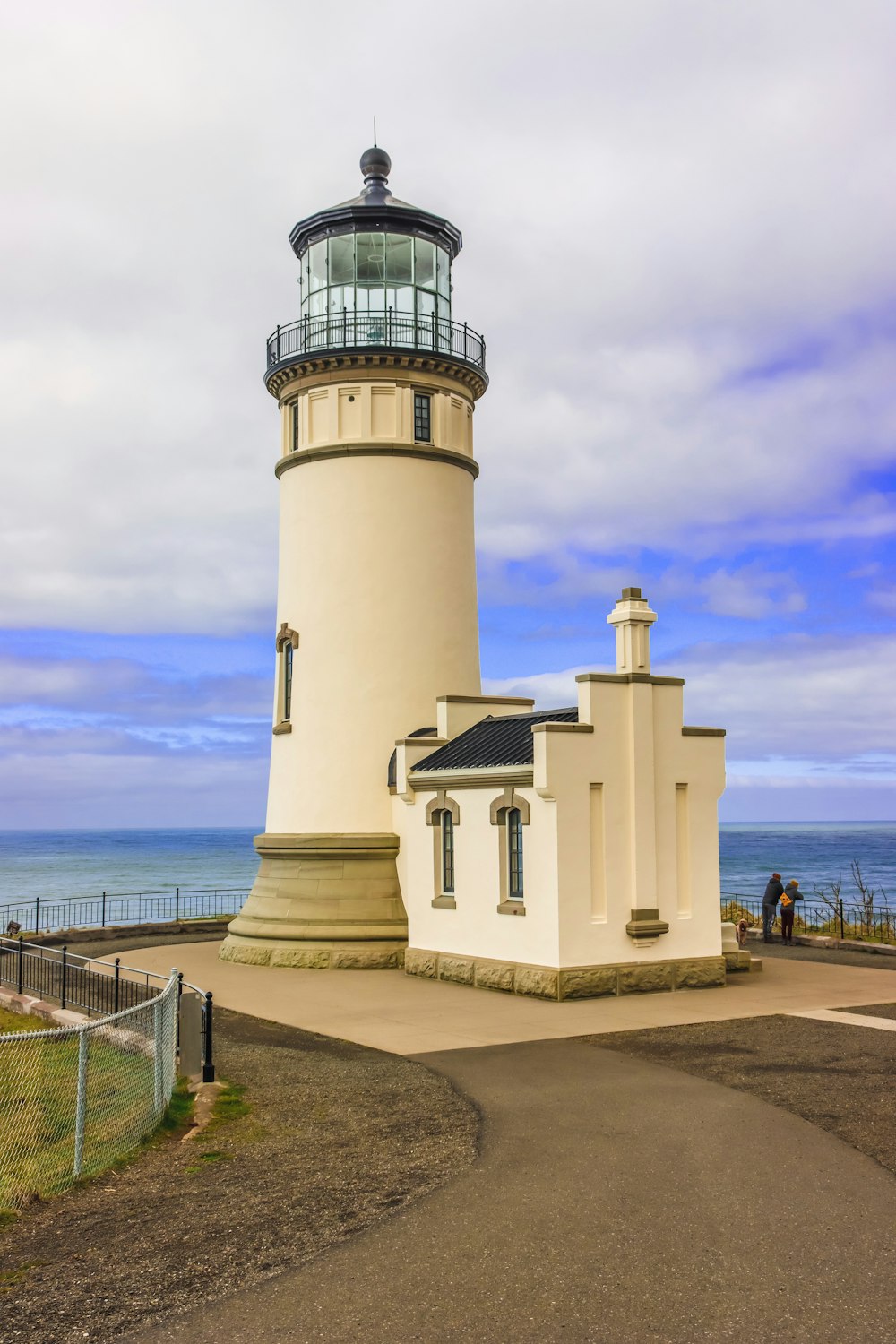 a light house sitting on top of a hill next to the ocean