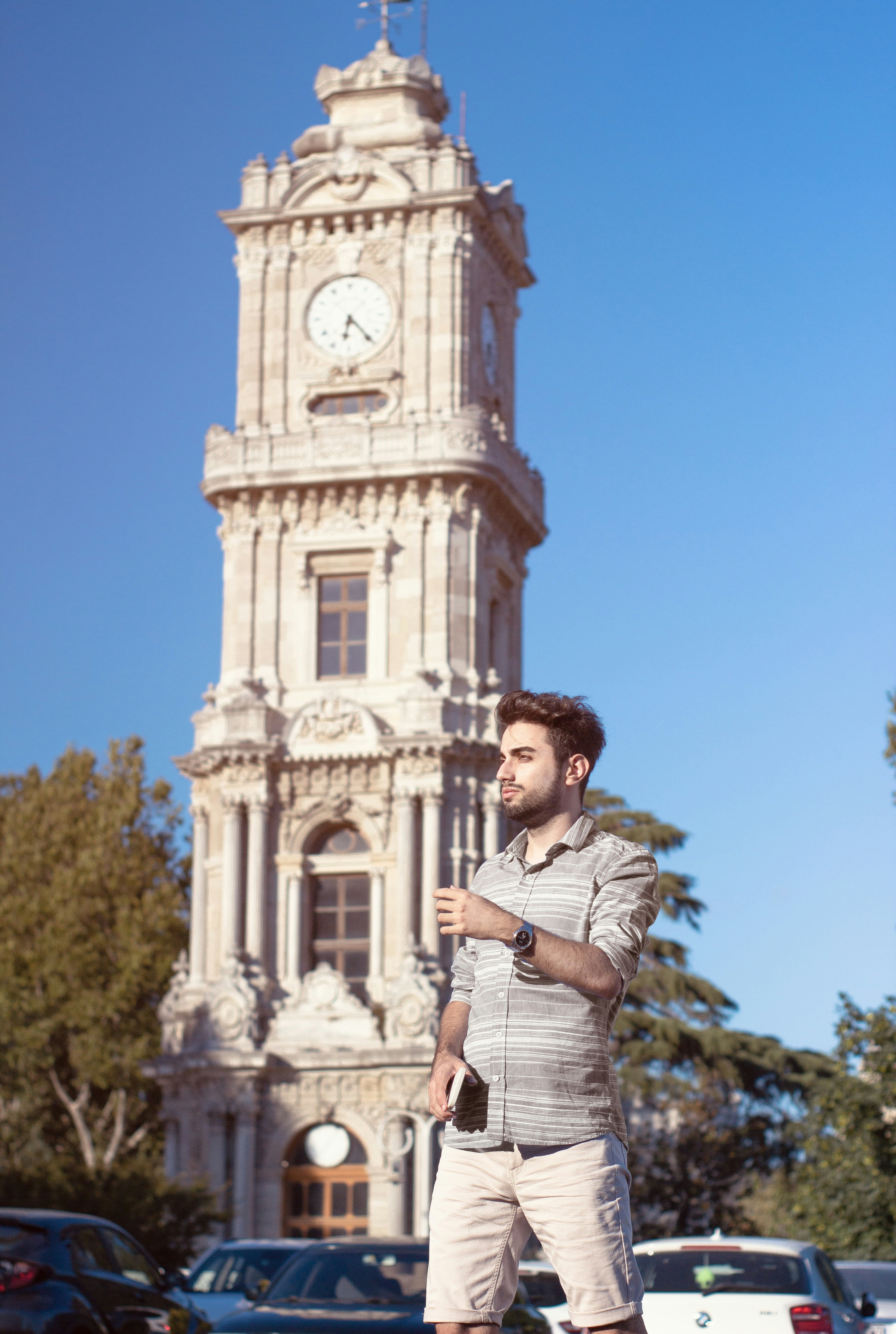 Ein Mann steht vor einem hohen Glockenturm