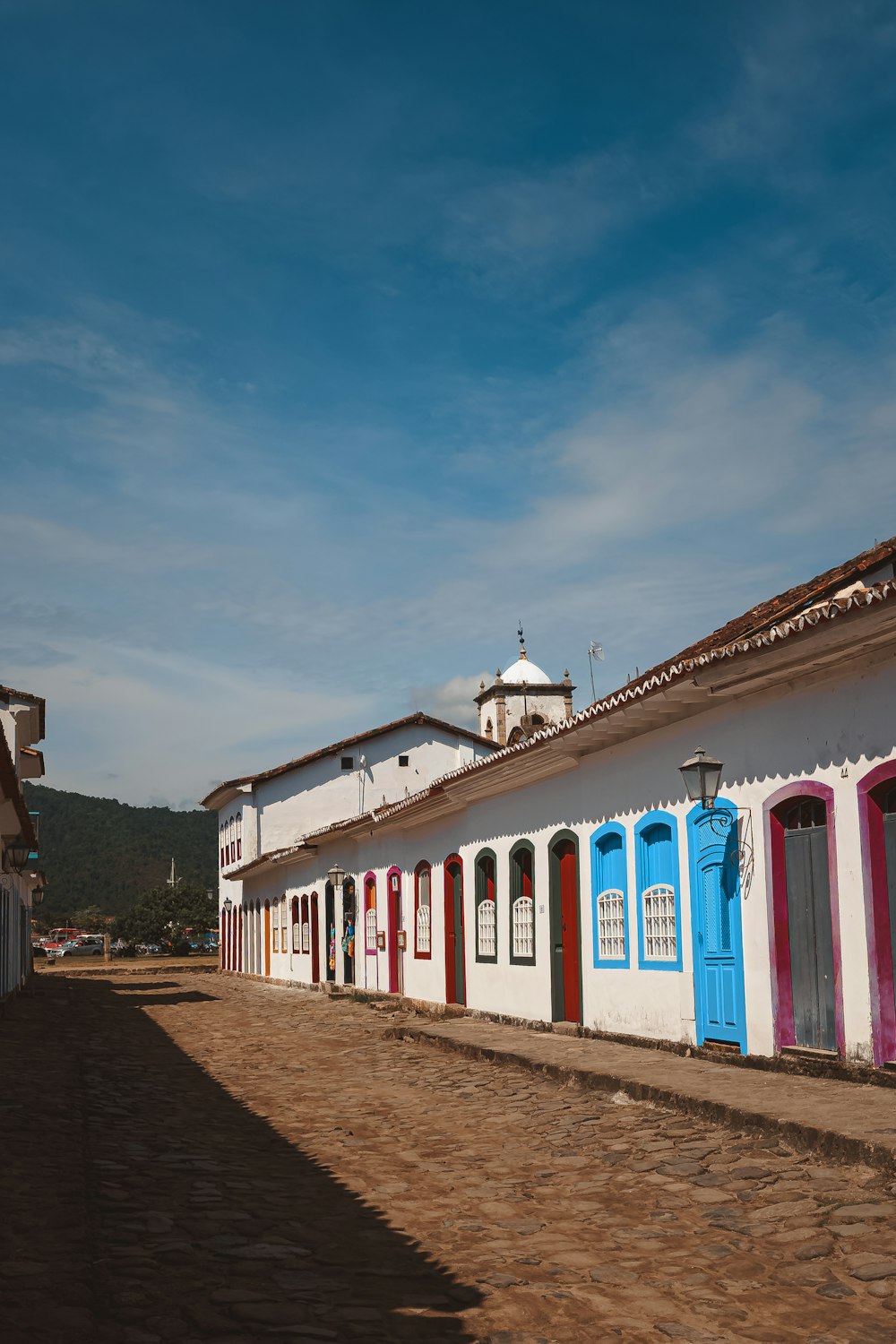 a cobblestone street lined with multicolored buildings