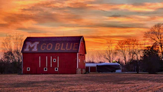 a red barn sitting in the middle of a field