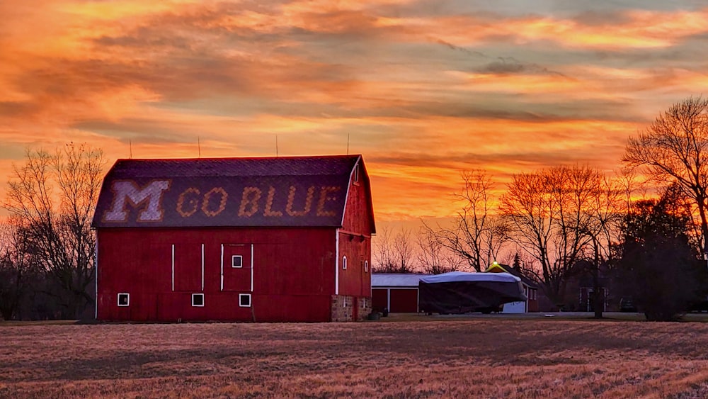 a red barn sitting in the middle of a field