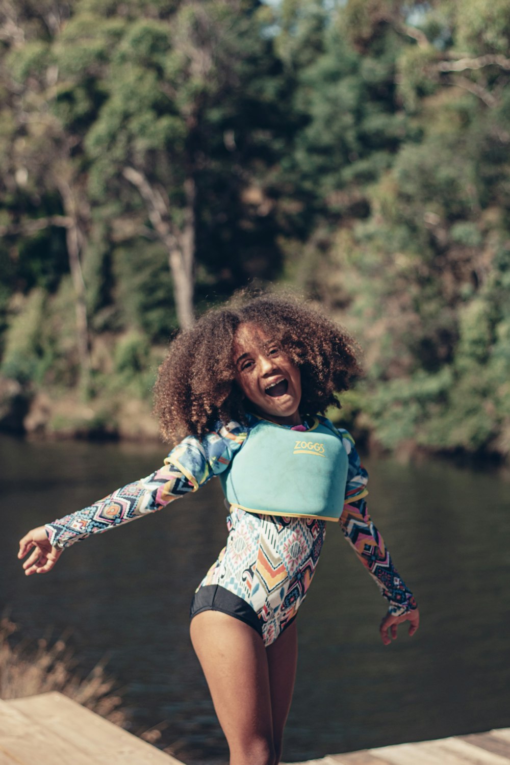 a young girl wearing a body suit on a dock