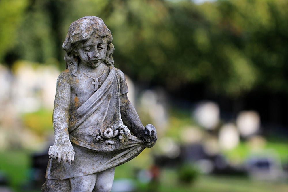 a statue of a little girl holding a bouquet of flowers