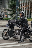 a man riding on the back of a motorcycle down a street